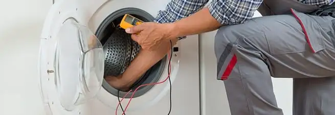 Dryer repair technician inspecting and repairing a clothes dryer in Jacksonville, FL