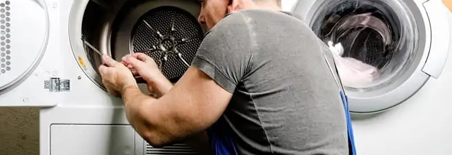 Dryer repair technician fixing a clothes dryer drum in Jacksonville, FL