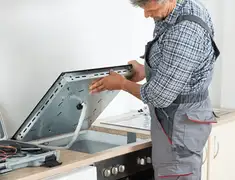 Appliance repair technician installing a built-in cooktop in Jacksonville, FL