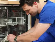 Dishwasher repair technician inspecting and servicing an open dishwasher in Jacksonville, FL