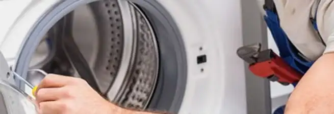 Appliance technician repairing a clothes dryer drum and internal parts in Jacksonville, FL