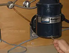 Garbage disposal repair technician tightening the mounting ring under a sink in Jacksonville, FL