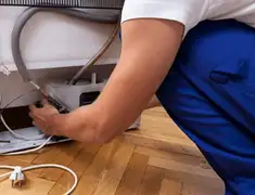 Appliance repair technician fixing refrigerator water line and connections in Jacksonville, FL