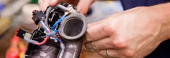 Vacuum repair technician reconnecting wiring and components in Jacksonville, FL