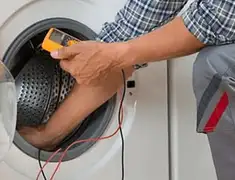 Washing machine repair technician testing a front-load washer with diagnostic tools in Jacksonville, FL