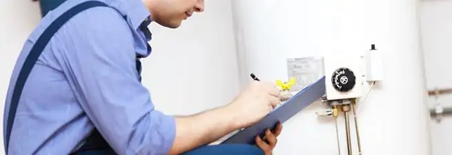 Water heater repair technician inspecting the unit and recording service notes in Jacksonville, FL