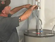 Water heater repair technician tightening supply line connections in Jacksonville, FL