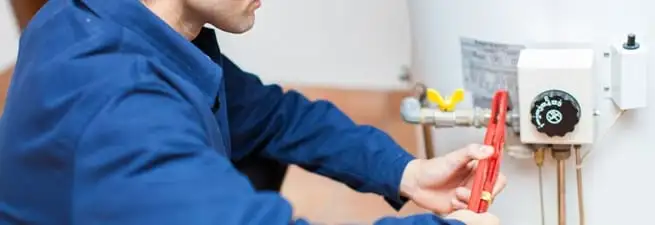 Water heater repair technician adjusting the temperature control and gas valve in Jacksonville, FL